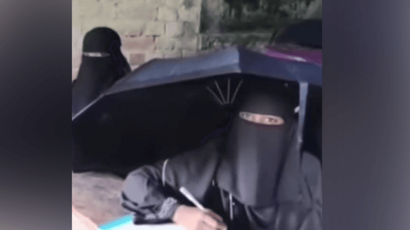 Students write exams with umbrellas as rain leaks through roof in Patuakhali