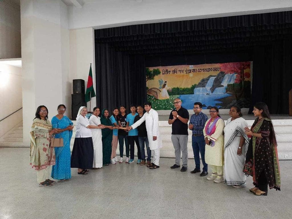 Holy Cross College stands beside women footballers from Janagaon