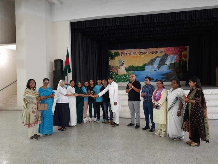 Holy Cross College stands beside women footballers from Janagaon
